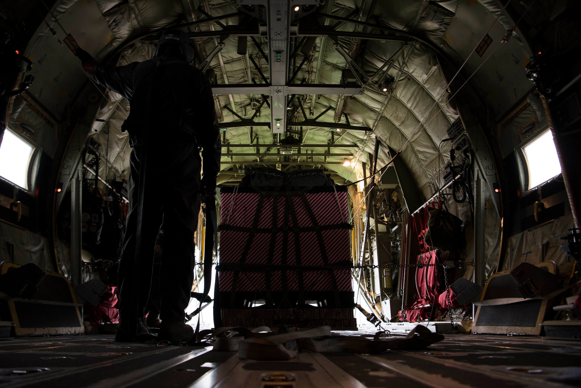U.S. Air Force Staff Sgt. Kellan Hyacinthe, 37th Airlift Squadron C-130J Super Hercules loadmaster, prepares cargo wrapped in Christmas wrapping paper to be dropped out the back of a U.S. Air Force C-130J for Operation Toy Drop 2017 over Alzey Drop Zone, Germany, Dec. 6, 2017. The operation was designed to improve interoperability with NATO allies. (U.S. Air Force photo by Senior Airman Devin M. Rumbaugh)