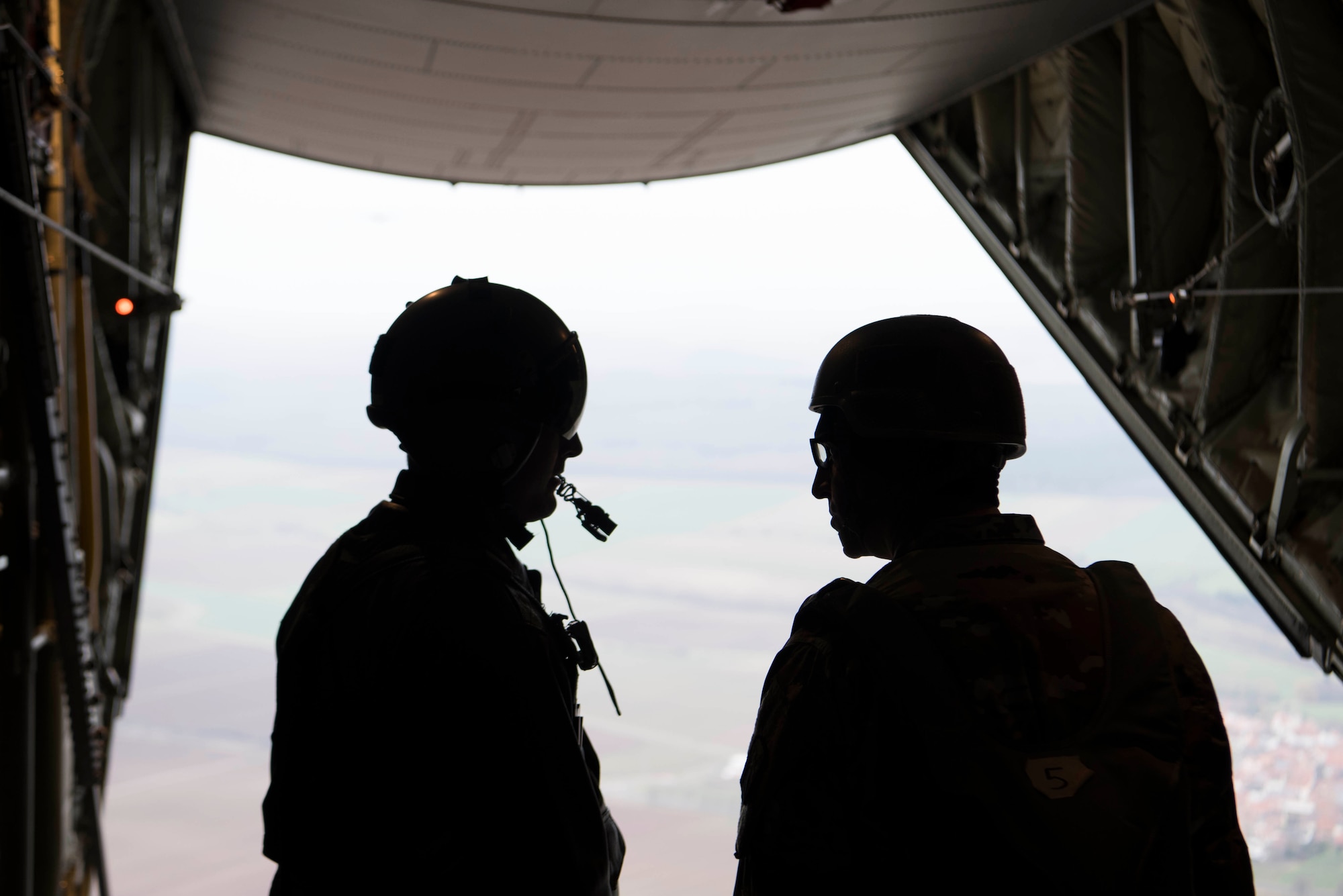 U.S. Air Force Master Sgt. Cecil Johnson, 37th Airlift Squadron C-130J Super Hercules loadmaster, speaks with a U.S. Army jumpmaster in a U.S. Air Force C-130J over Alzey Drop Zone, Germany Dec. 6, 2017. Paratroopers with the U.S. Air Force, U.S. Army, German, Italian, Dutch, British, and Estonian militaries participated in Operation Toy Drop 2017 to maintain their military free fall and jumpmaster proficiencies. (U.S. Air Force photo by Senior Airman Devin M. Rumbaugh)