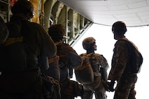 A U.S. Army paratrooper speaks to the U.S. Army jumpmaster prior to jumping out of the U.S. Air Force C-130J Super Hercules over Alzey Drop Zone, Germany, Dec. 6, 2017. The paratroopers performed static-line jumps out of the aircraft as a part of Operation Toy Drop 2017. (U.S. Air Force photo by Senior Airman Devin M. Rumbaugh)