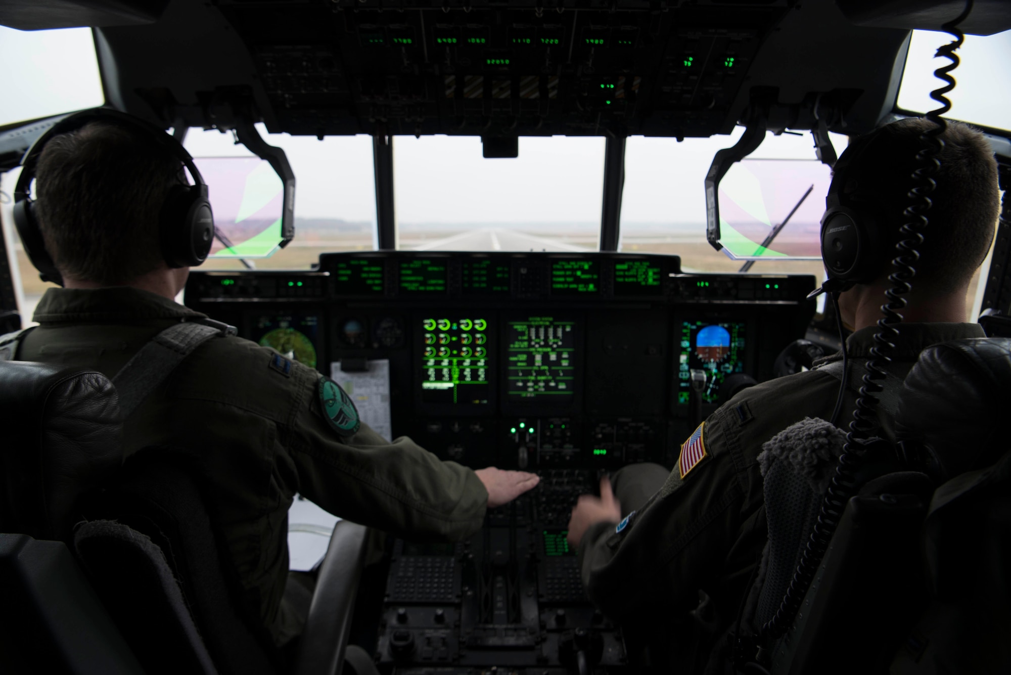U.S. Air Force Capt. Jared Johnson (left) and U.S. Air Force 1st Lt. Kyle Holzem, both C-130J Super Hercules pilots assigned to the 37th Airlift Squadron, take off for Operation Toy Drop 2017, in a U.S. Air Force C-130J on Ramstein Air Base, Germany, Dec. 6, 2017. The aircraft flew over Alzey Drop Zone, Germany, where paratroopers from the U.S. Army, U.S. Air Force, German, Italian, Dutch, British, and Estonian militaries performed static-line jumps out of the aircraft. (U.S. Air Force photo by Senior Airman Devin M. Rumbaugh)