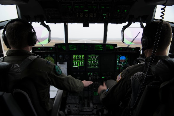 U.S. Air Force Capt. Jared Johnson (left) and U.S. Air Force 1st Lt. Kyle Holzem, both C-130J Super Hercules pilots assigned to the 37th Airlift Squadron, take off for Operation Toy Drop 2017, in a U.S. Air Force C-130J on Ramstein Air Base, Germany, Dec. 6, 2017. The aircraft flew over Alzey Drop Zone, Germany, where paratroopers from the U.S. Army, U.S. Air Force, German, Italian, Dutch, British, and Estonian militaries performed static-line jumps out of the aircraft. (U.S. Air Force photo by Senior Airman Devin M. Rumbaugh)