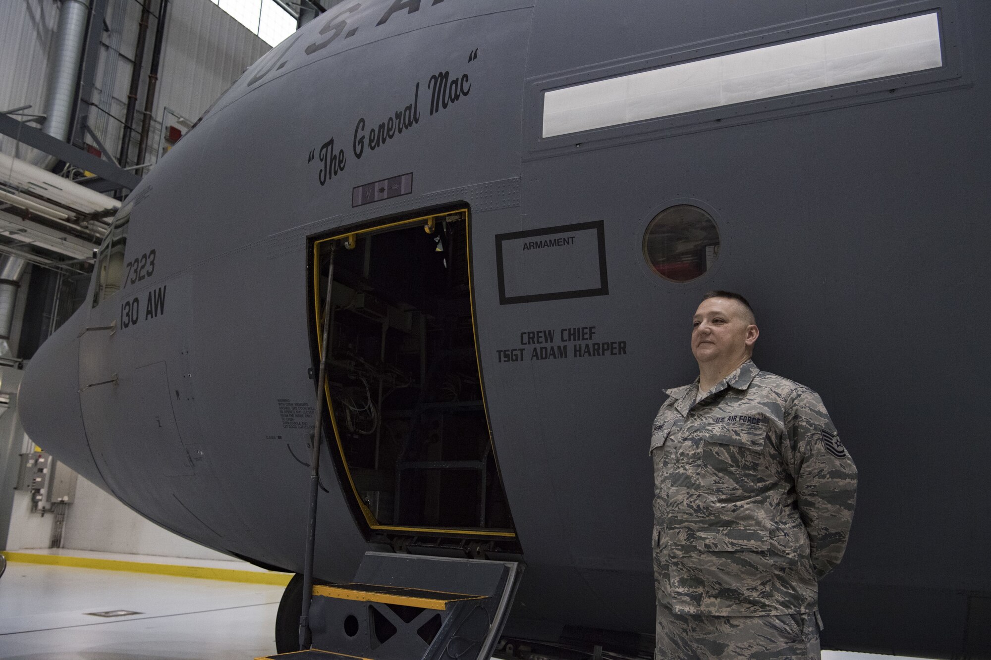 U.S. Air Force Tech. Sgt. Adam Harper, a crew chief for the 130th Maintenance Group, stands by a C-130H at a plane naming ceremony Dec. 7, 2017 at McLaughlin Air National Guard Base, Charleston, W.Va. The aircraft was given the name “The General Mac” to honor Brig. Gen. (ret) James K. McLaughlin, who founded the West Virginia Air National Guard and was a pilot in World War II with the famous Eight Air Force. (U.S. Air National Guard photo by Tech. Sgt. De-Juan Haley)