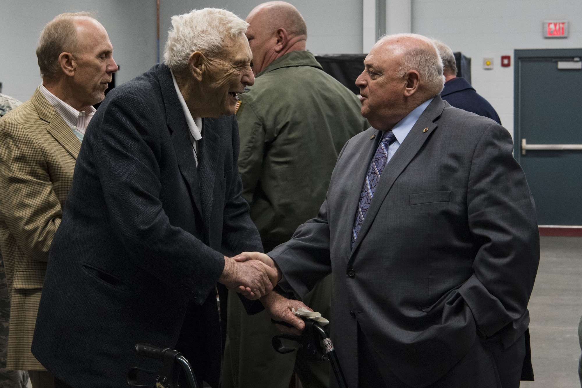 Retired U.S. Air Force Brig. Gen. J. Kemp McLaughlin shakes the hand of Retired U.S. Army Maj. Gen. Allen Tackett at a C-130H plane naming ceremony Dec. 7, 2017 at McLaughlin Air National Guard Base, Charleston, W.Va. The aircraft was given the name “The General Mac” to honor McLaughlin, who founded the West Virginia Air National Guard and was a pilot in World War II with the famous Eight Air Force. (U.S. Air National Guard photo by Airman Caleb Vance)