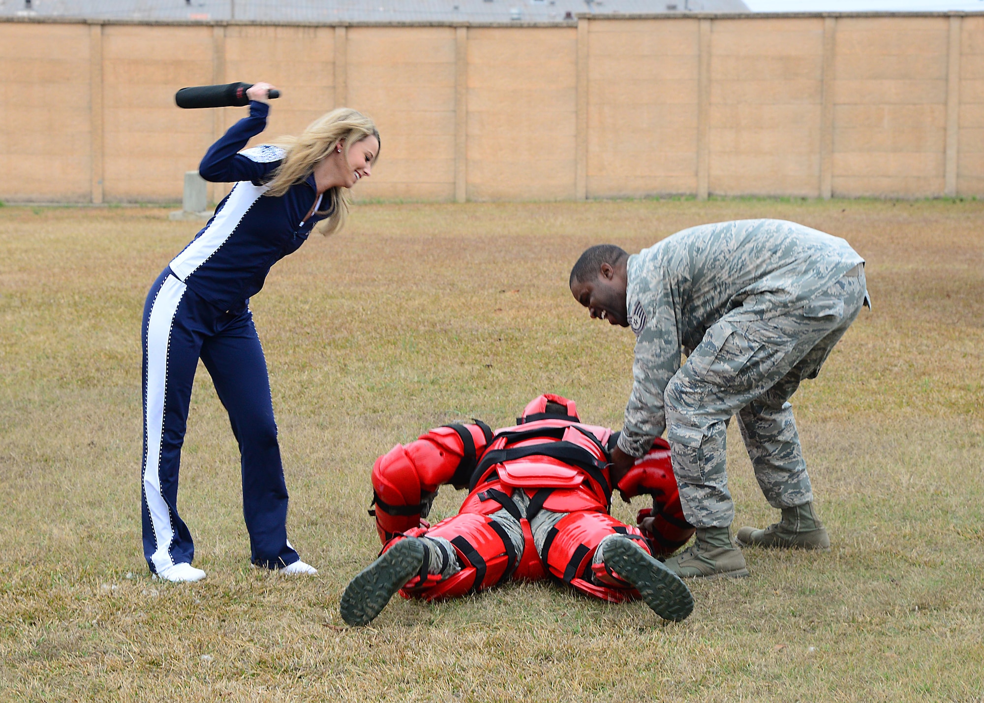 Maggie, a Dallas Cowboys Cheerleader, participates in a hand-to-hand combat simulation with Senior Airman Jasson Adamson, 14th Security Forces Squadron unit trainer, and Tech. Sgt. Miguel Stewart, 14th SFS NCO in Charge of Training, Dec. 4, 2017, on Columbus Air Force Base, Mississippi. The demonstration was part of a tour visit the cheerleaders made to the base. (U.S. Air Force photo by Airman 1st Class Beaux Hebert)