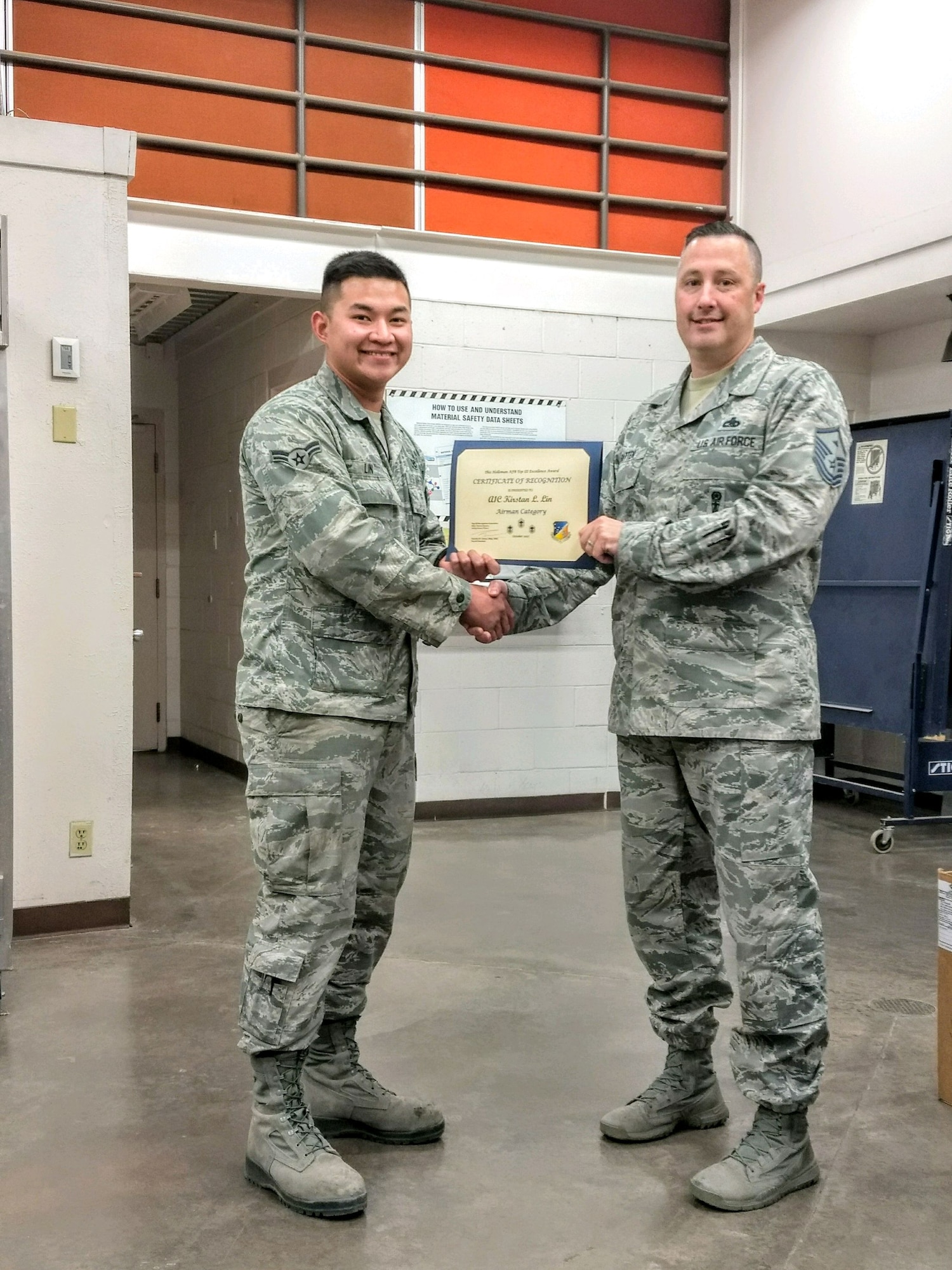 Airman 1st Class Kirstan Lin, 49th Civil Engineer Squadron Heating, Ventilation and Air Conditioning apprentice, receives the June Top III Airman Award from Master Sgt. Timothy Gatten, 54th Aircraft Maintenance Squadron first sergeant and Top III president, Nov. 28, 2017, at Holloman Air Force Base, N.M. During the month of October, Lin responded to emergency calls concerning inoperative cooling equipment at the Next-Generation Radar Weather Forecast Operations building. He repaired critical air conditioning systems restoring cooling to a $2 million radar providing weather coverage for 48,000 square miles and 800,000 people. His efforts allowed forecasting to resume enabling weather coverage for the local area leading to 5,312 flying operations and 656 training hours.