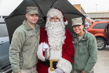 Members of the Joint Base San Antonio-Lackland community pose for a photo with Santa at JBSA-Lackland during the Trees for Troops program Dec. 7, 2017.