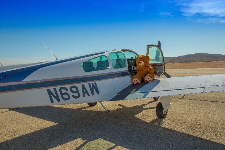 Theodore Gablin, President of the Redlands Airport Association, poses with one of the bicycles donated to the Toys for Tots foundation at the Twentynine Palms airport Dec. 2, 2017. This event marked the third-annual Toys for Tots Fly-in. (U.S. Marine Corps photo by Lance Cpl. Ashlee Conover)