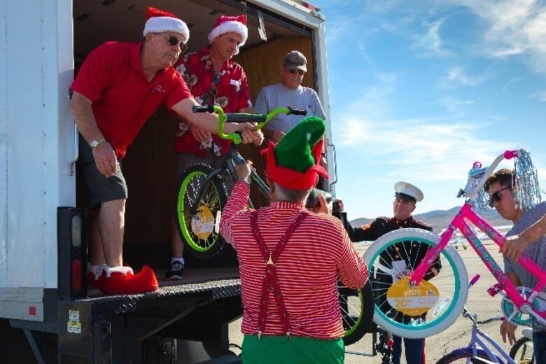 Theodore Gablin, President of the Redlands Airport Association, poses with one of the bicycles donated to the Toys for Tots foundation at the Twentynine Palms airport Dec. 2, 2017. This event marked the third-annual Toys for Tots Fly-in. (U.S. Marine Corps photo by Lance Cpl. Ashlee Conover)