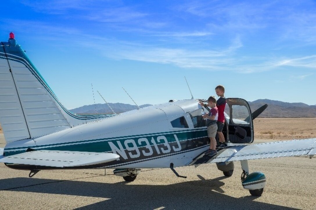 Theodore Gablin, President of the Redlands Airport Association, poses with one of the bicycles donated to the Toys for Tots foundation at the Twentynine Palms airport Dec. 2, 2017. This event marked the third-annual Toys for Tots Fly-in. (U.S. Marine Corps photo by Lance Cpl. Ashlee Conover)