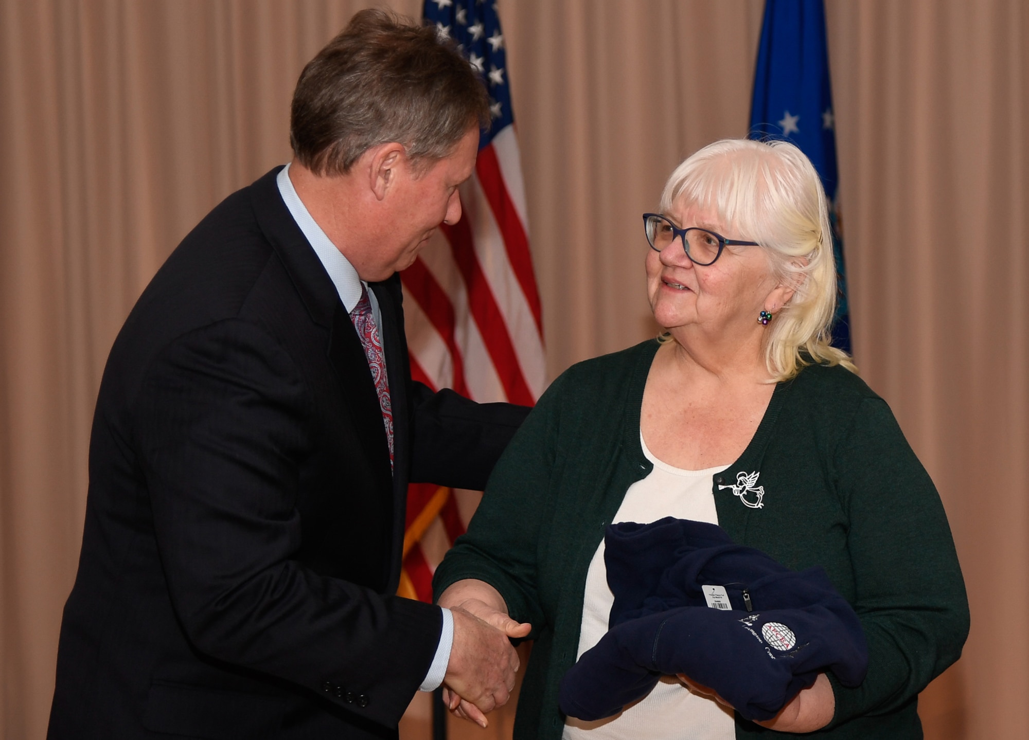 Patrick Dagle, the Armed Forces Communications and Electronics Association Lexington-Concord Chapter president, congratulates Gloria Atencio, Air Force Life Cycle Management Center Contracting Directorate functional staff, on being named a 2017 Unsung Hero during a ceremony at the Minuteman Commons Dec. 6.