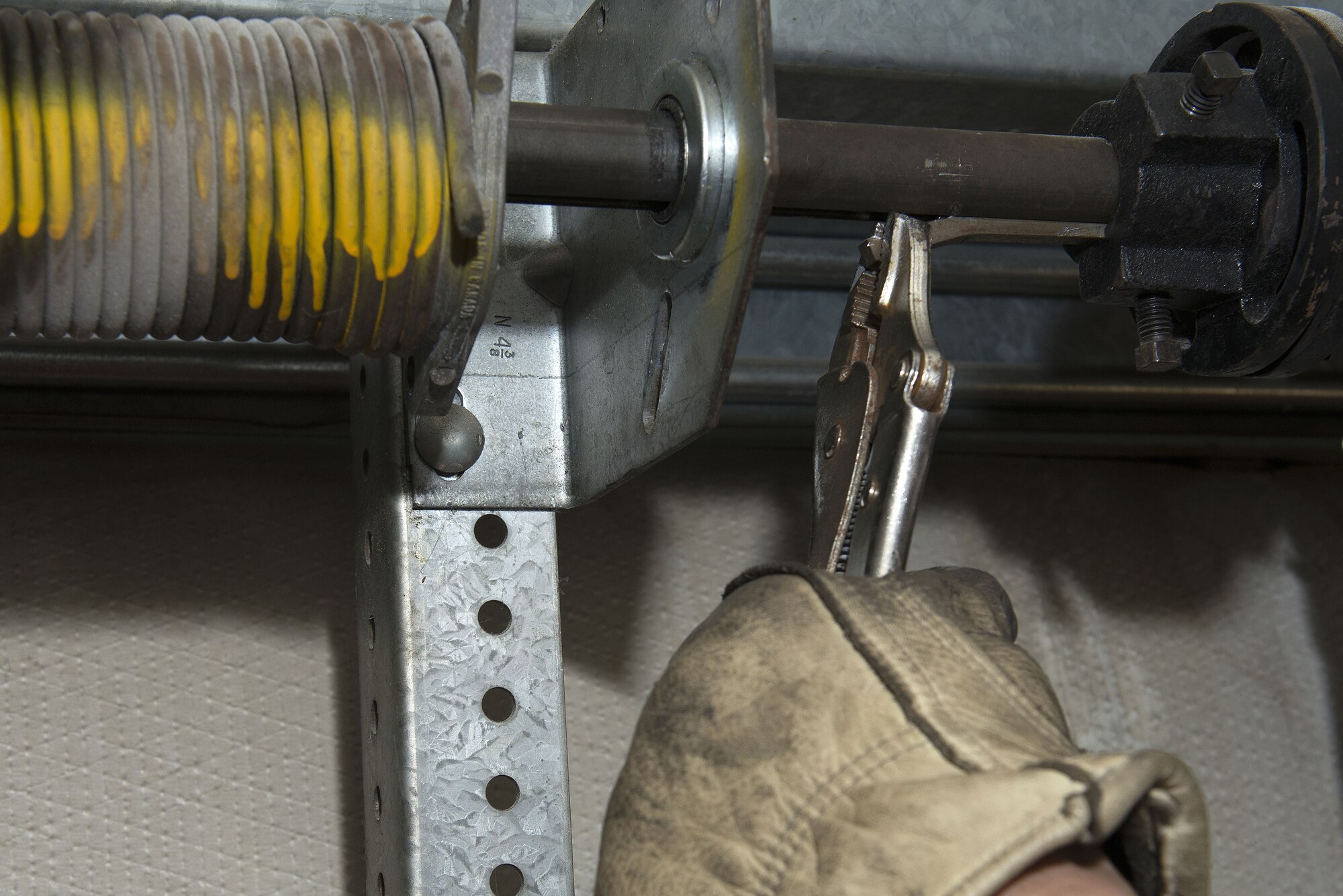 Fred Wing Jr., 773d Civil Engineer Squadron senior overhead door systems mechanic, removes a piece of metal at the car wash on Joint Base Elmendorf-Richardson, Alaska. The construction shop repairs and performs maintenance on doors, windows, framing, airfield damage and much more.