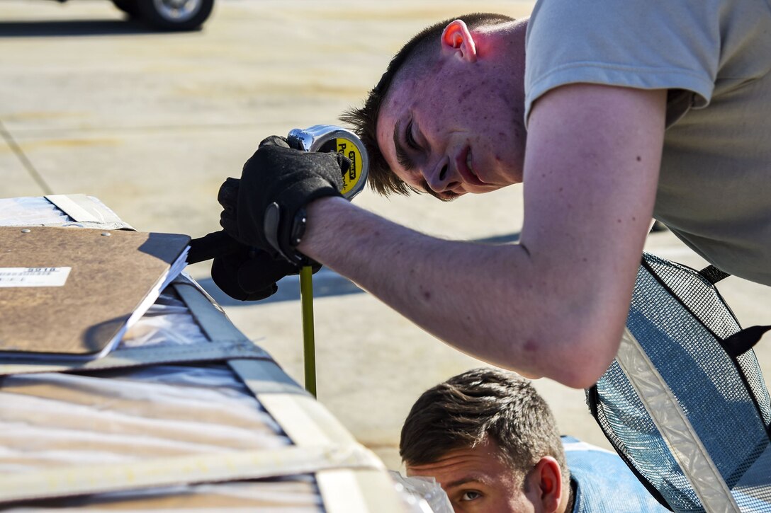 Airman 1st Class Steven Raulston, 23d Logistics Readiness Squadron fuels distribution operator, measures the height of cargo, Dec. 4, 2017, at Moody Air Force Base, Ga. Moody’s Phase 1, Phase 2 exercise tested the 23d Wing’s operations, maintenance and logistics squadron’s readiness to rapidly deploy. Airmen from the 23d Logistics Readiness Squadron where evaluated on their ability to inspect 30 units of cargo estimated to weigh 70 tons efficiently when received in a rapid manner. (U.S. Air Force photo by Airman Eugene Oliver)