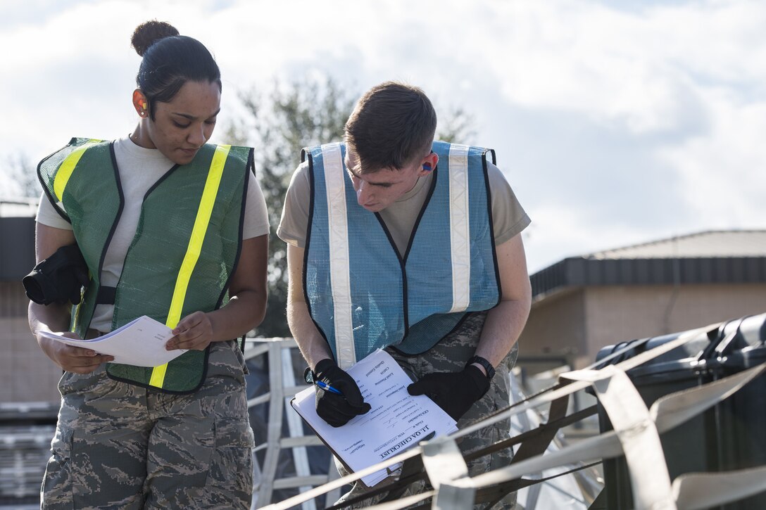 Airman 1st Class Camille Hernandez, 23d Logistics Readiness Squadron traffic management apprentice, and Airman 1st Class Seven Raulston 23d LRS fuels distribution operator, complete paperwork during an exercise, Dec. 4, 2017, at Moody Air Force Base, Ga. Moody’s Phase 1, Phase 2 exercise tested the 23d Wing’s ability to prepare, deploy and execute their mission at a moment’s notice. Airmen from the 23d Logistics Readiness Squadron were evaluated on their ability to prepare, pack and ship supplies for squadrons tasked to deploy. (U.S. Air Force photo by Senior Airman Janiqua P. Robinson)