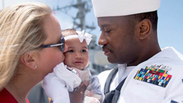 A sailor holds his newborn daughter