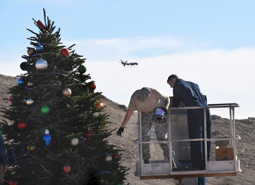 Two Creech Air Force Base members decorate a Christmas tree Dec. 2, 2017, at Creech AFB, Nev. Diamond Resorts International donated the tree and decorations as a thank you to Creech service members and their families. (U.S. Air Force photo/Senior Airman Christian Clausen)