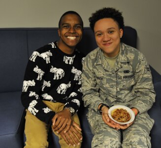 Airman 1st Class Joshua Hall, left, 437th Aerial Port Squadron air cargo services technician, smiles with Airman 1st Class Kaylyn Carrier, right, 628th Logistics Readiness Squadron logistics planner during a dormitory dinner hosted for Airmen Dec. 6, 2017, at Joint Base Charleston, S.C.