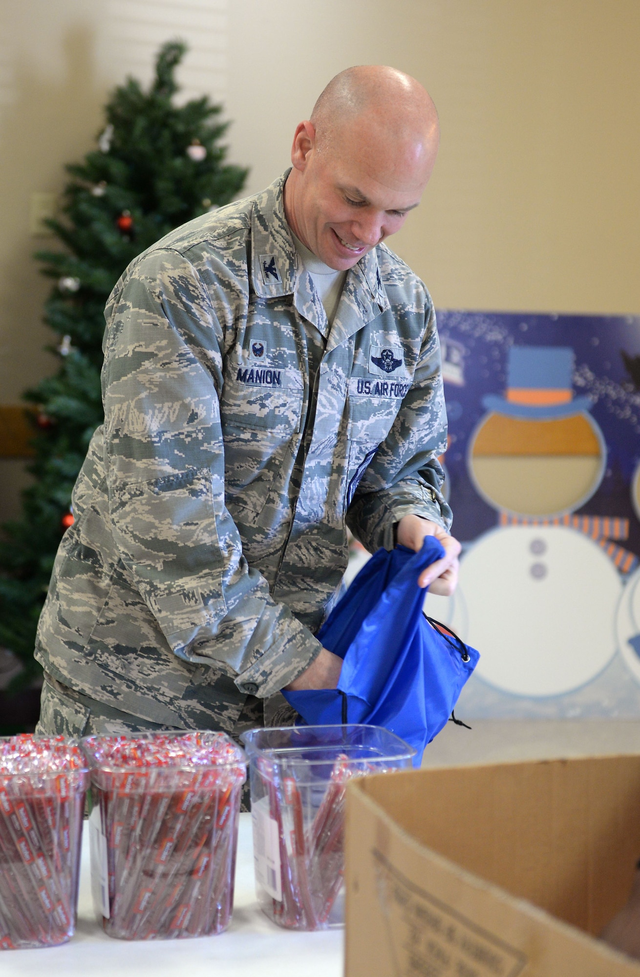 Col. Michael Manion, 55th Wing commander, helps assemble bags filled with food, treats, and thank you’s at the Bellevue Volunteer Fire Department hall in Bellevue, Neb. Dec. 5, 2017 as part of “Operation Holiday Cheer."