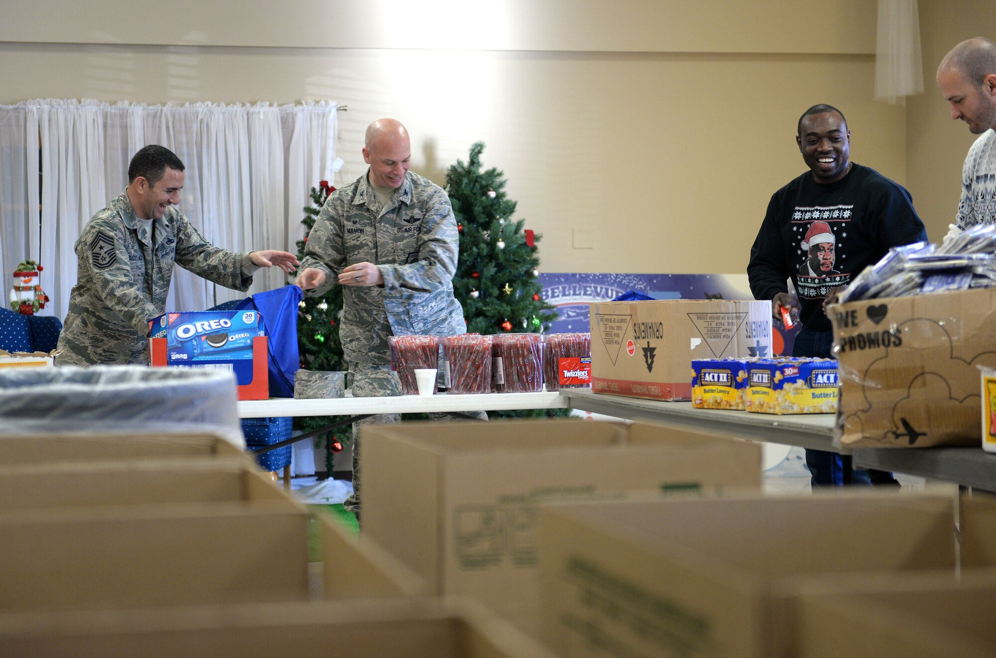 Col. Michael Manion, 55th Wing commander, and 55th Wing Command Chief Master Sgt. Brian Kruzelnick help assemble bags filled with food, treats, and thank you’ s at the Bellevue Volunteer Fire Department hall in Bellevue, Neb. Dec. 5, 2017 as part of “Operation Holiday Cheer.”