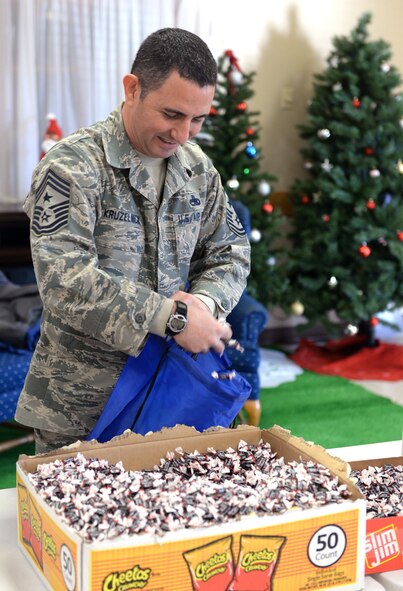 Command Chief Master Sgt. Brian Kruzelnick, 55th Wing command chief, helps assemble bags filled with food, treats, and thank you’ s at the Bellevue Volunteer Fire Department hall in Bellevue, Neb. Dec. 5, 2017 as part of “Operation Holiday Cheer.”