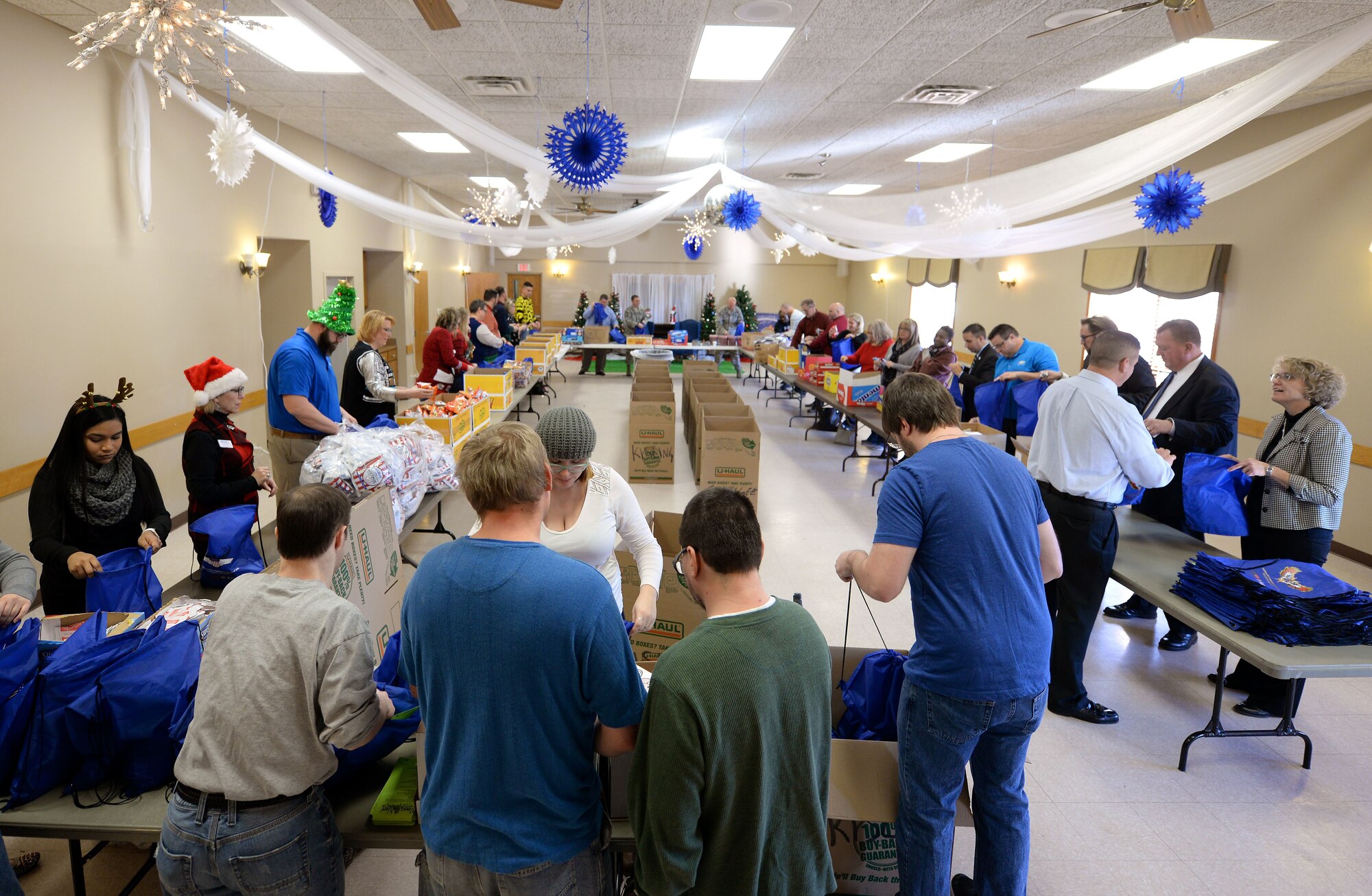 Volunteers with “Operation Holiday Cheer” assemble bags filled with food, treats, and thank you’ s at the Bellevue Volunteer Fire Department hall in Bellevue, Neb. Dec. 5, 2017.