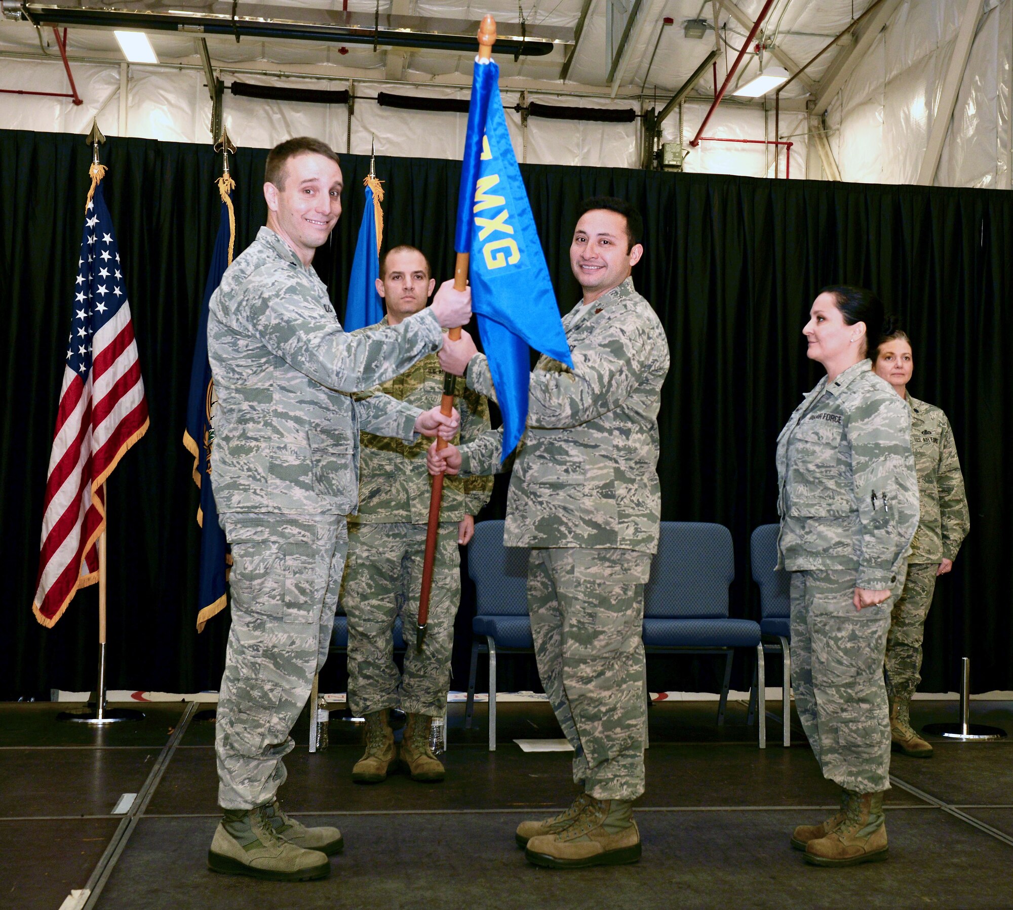 Lt. Col. Brian R. Jusseaume, commander of the 157th Maintenace Group, passes the 157th MXG guidon to Maj. Nicolas S. Alcocer during a change of command ceremony on December 2, 2017, at Pease Air National Guard Base, N.H. Alcocer took commmand of the 157th Maintenance Operations Flight. (N.H. Air National Guard photo by Staff Sgt. Kayla Rorick)