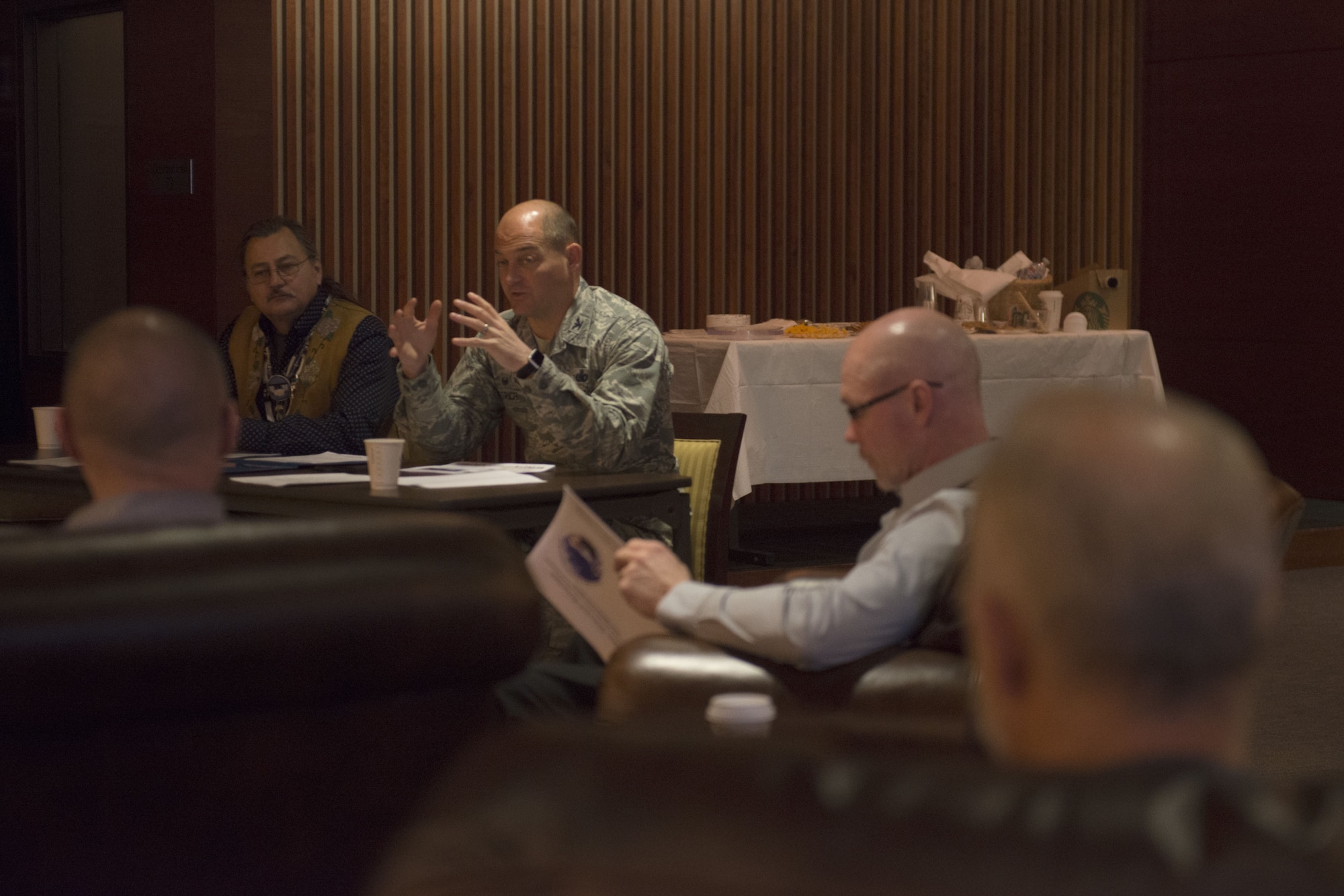 Air Force Col. George Dietrich, 673d Air Base Wing and Joint Base Elmendorf-Richardson commander, and Gary Harrison, Chickaloon Native Village chief, discuss a memorandum of agreement at the Arctic Warrior Events Center at JBER, Alaska, Dec. 5, 2017. The MOA served to establish a relationship between JBER and the CNV to converse on mutual concerns, support and coordinate management of resources.