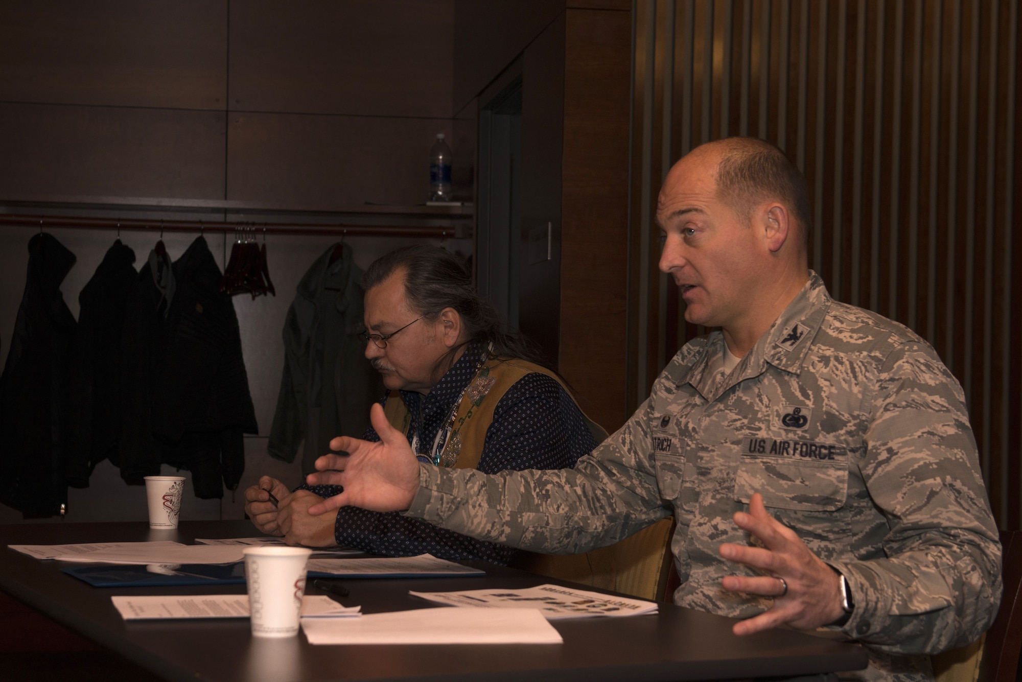 Air Force Col. George Dietrich, 673d Air Base Wing and Joint Base Elmendorf-Richardson commander, and Gary Harrison, Chickaloon Native Village chief, discuss a memorandum of agreement at the Arctic Warrior Events Center at JBER, Alaska, Dec. 5, 2017. The MOA served to establish a relationship between JBER and the CNV to converse on mutual concerns, support and coordinate management of resources.