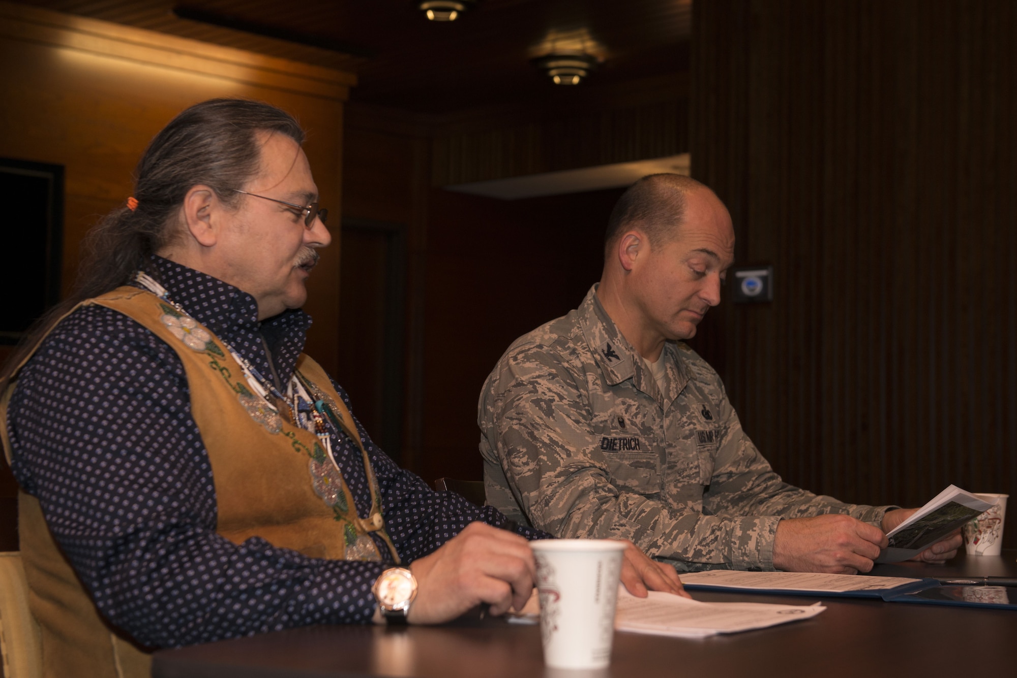 Gary Harrison, Chickaloon Native Village chief, and Air Force Col. George Dietrich, 673d Air Base Wing and Joint Base Elmendorf-Richardson commander, discuss a memorandum of agreement at the Arctic Warrior Events Center at JBER, Alaska, Dec. 5, 2017. The MOA served to establish a relationship between JBER and the CNV to converse on mutual concerns, support and coordinate management of resources.