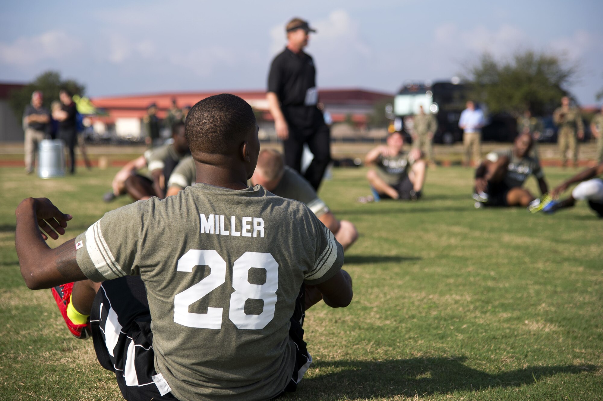 U.S. Air Force Airman 1st Class William Miller, a firefighter assigned to the 6th Civil Engineer Squadron, stretches during a football camp hosted by Jon Gruden, a Monday Night Football color analyst, at MacDill Air Force Base, Fla., Dec. 8, 2017. Miller was one of approximately 30 MacDill personnel who volunteered to participate in this event to learn football from a Super Bowl winning coach.