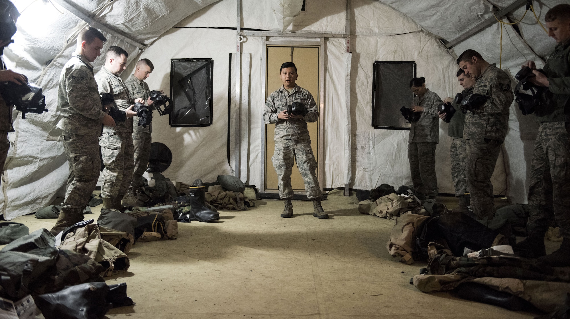 Senior Airman Co Nguyen, 92nd Civil Engineer Squadron logistics journeyman, teaches a group of Fairchild Airmen about chemical, biological, radiological, nuclear equipment during an exercise, at Fairchild Air Force Base, Washington Nov. 30, 2017. Emergency management instructors are extensively trained on all CBRN gear using live agents to help them build confidence in their equipment and our methods of detecting and decontaminating contaminants. (U.S. Air Force photo/ Senior Airman Sean Campbell)
