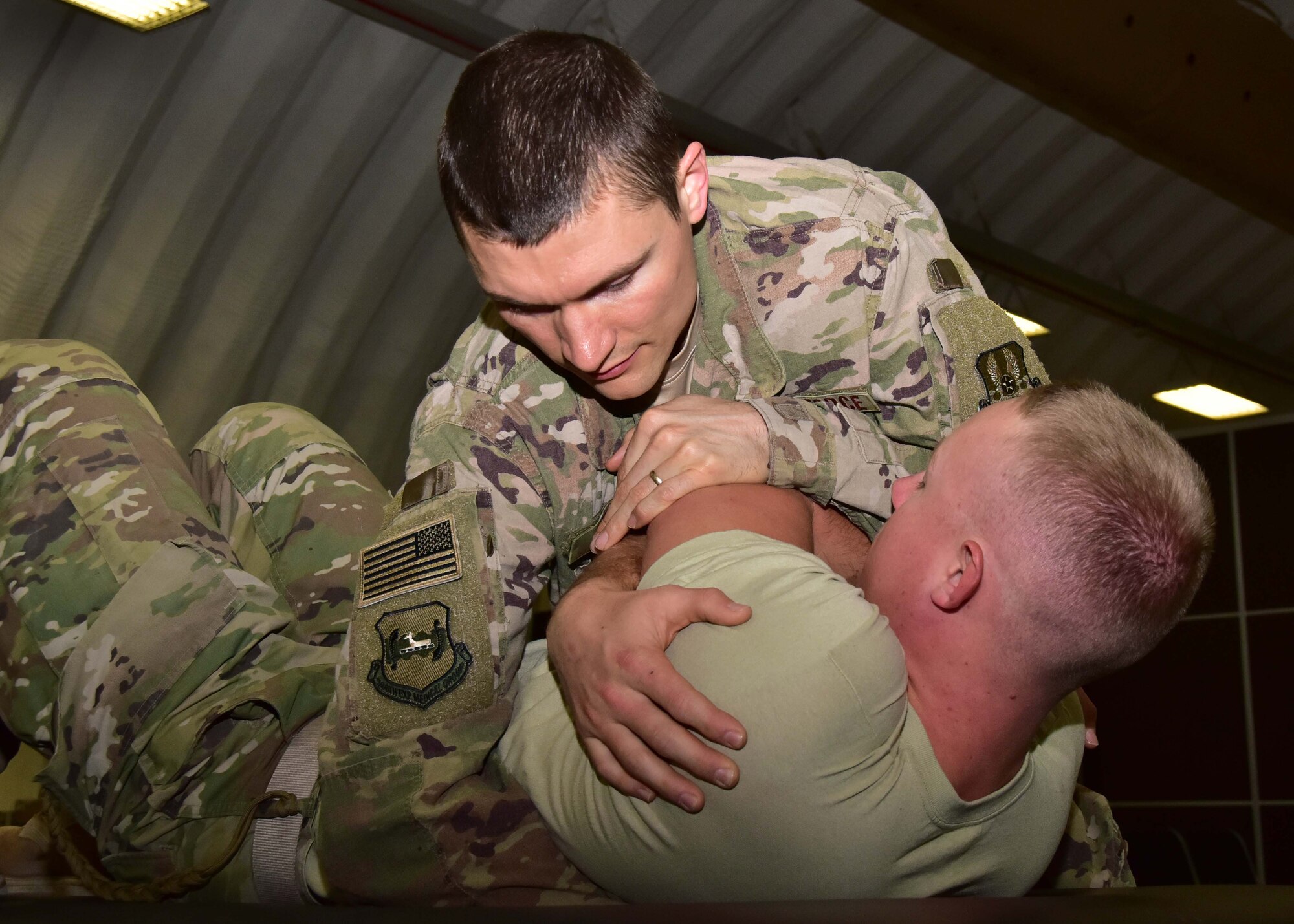 Capt. Eric Walter, 386th Expeditionary Medical Group physical therapy element chief, uses thoracic manipulation to treat Senior Airman Calvin Lourens, 386th Expeditionary Logistics Readiness Squadron passenger service specialist at an undisclosed location in Southwest Asia, Dec. 7, 2017. (U.S. Air Force photo by Tech. Sgt. Louis Vega Jr.)