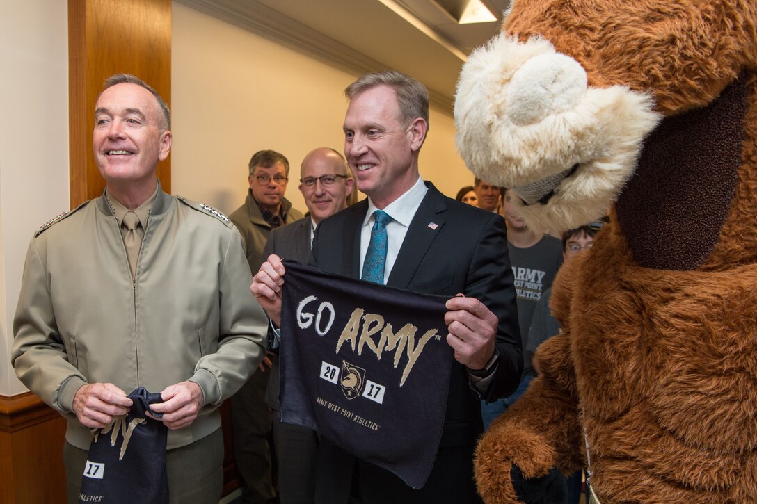 Deputy Defense Secretary Patrick M. Shanahan and Marine Corps Gen. Joseph F. Dunford Jr., chairman of the Joint Chiefs of Staff, hold Army shirts while standing with a mascot