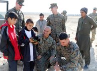 U.S. Marines assigned to the Georgian Liaison Team - a joint Coalition Patrol Team - laugh with two children they helped save after a Taliban suicide bombing attack Nov. 22, 2017.