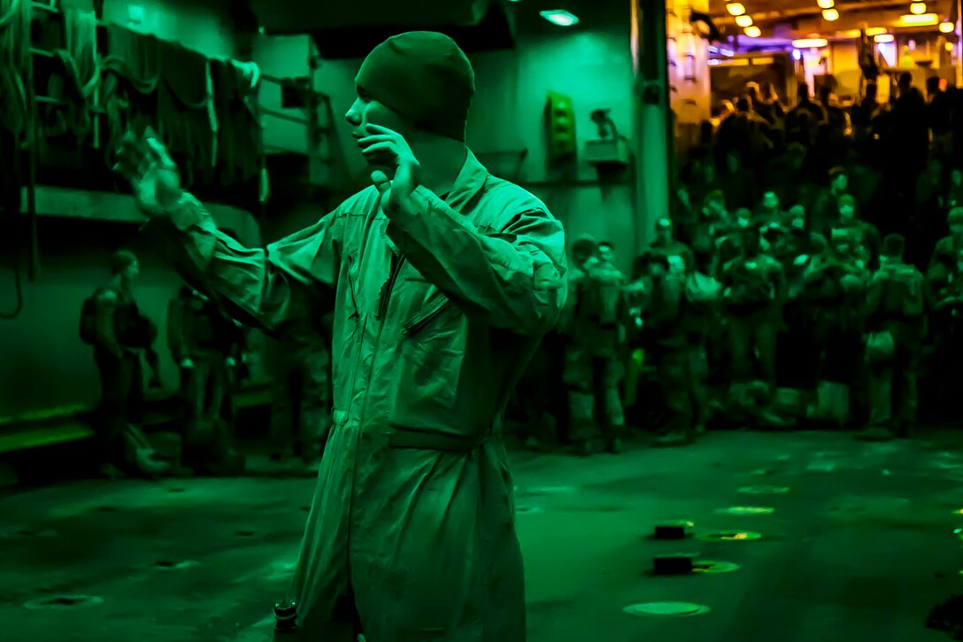 A U.S. Marine with the Assault Amphibious Vehicle (AAV) Platoon, Fox Company, Battalion Landing Team, 2nd Battalion, 6th Marine Regiment, 26th Marine Expeditionary Unit (MEU), ground guides an AAV on the well deck of the dock landing ship USS Oak Hill (LSD 51) in the Atlantic Ocean, prior to conducting a mechanized raid at Camp Lejeune, N.C., Dec. 7, 2017, to complete Combined Composite Training Unit Exercise (COMPTUEX). Combined COMPTUEX allows all elements of the Marine Air Ground Task Force to join and train in realistic scenarios so the MEU as a whole can meet its Predeployment Training Program objectives prior to an upcoming deployment at sea. (U.S. Marine Corps photo by Staff Sgt. Dengrier M. Baez)