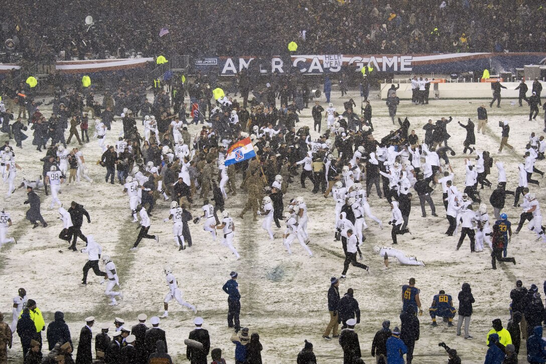 Soldiers rush onto the football field.