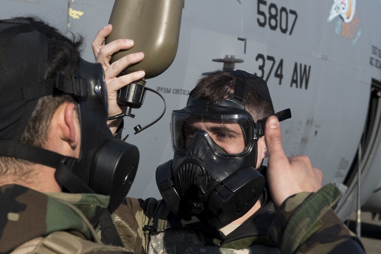 Airmen with the 374th Aircraft Maintenance Squadron perform checks to ensure they can receive water through their chemical, biological, radiological and nuclear protective gear during exercise Vigilant Ace 18, Dec. 6, 2017, at Yokota Air Base, Japan.