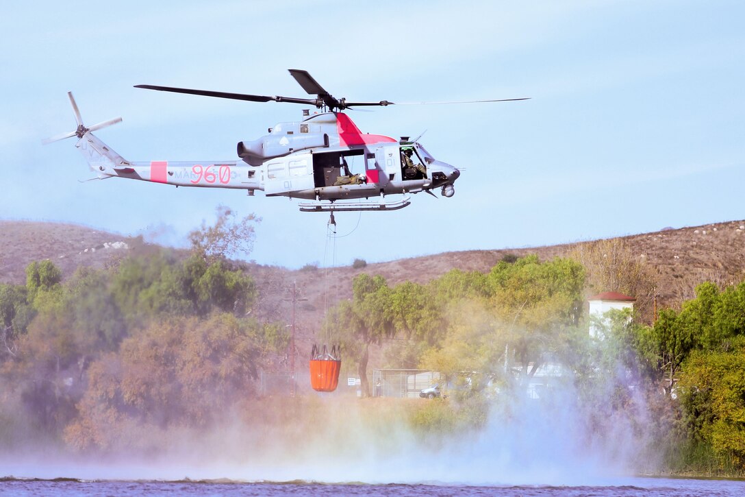 A helicopter flies above water.