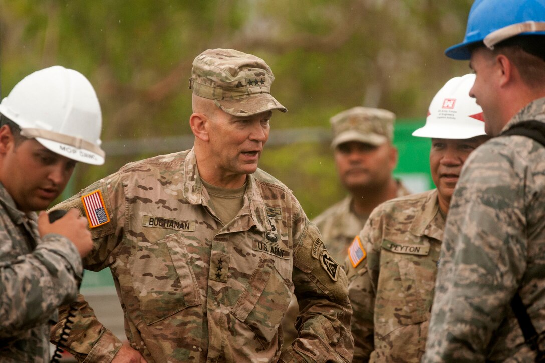 An Army general speaks with Air Force engineers