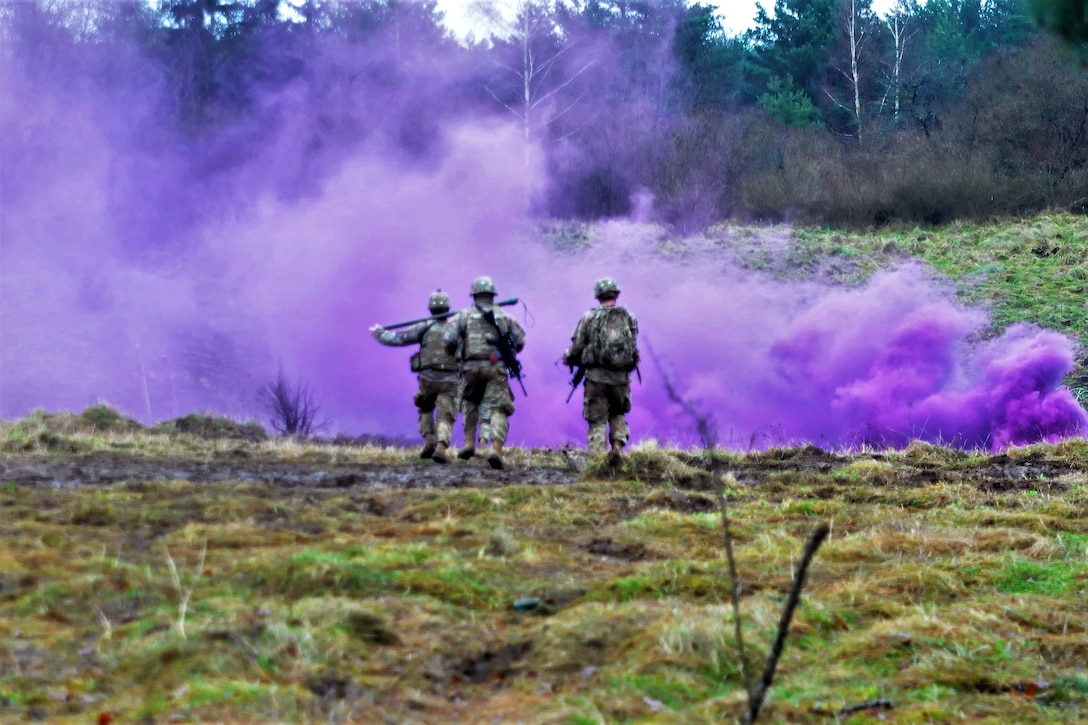 Three soldiers walk toward purple smoke.
