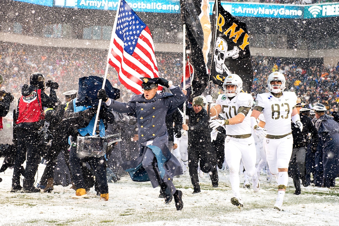 Cadets and Army Black Knight football players rush onto the field before the start of the 118th Army-Navy game.