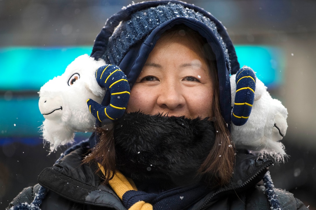 A Navy fan wears U.S. Naval Academy mascot earmuffs.