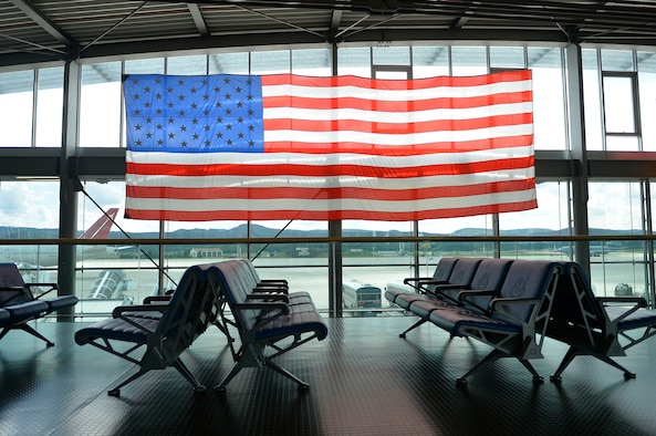 A U.S. flag hangs over the passenger terminal on Ramstein Air Base, Germany, Aug. 14, 2017. Officials assigned to the 86th Airlift Wing encouraged military members and government civilians to stay vigilant while going about their business or taking leisure. (U.S. Air Force photo by Airman 1st Class Joshua Magbanua)