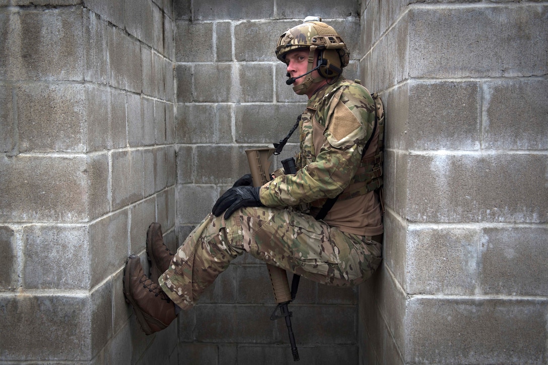 An airman maneuvers into building walls while listening to an instructor.