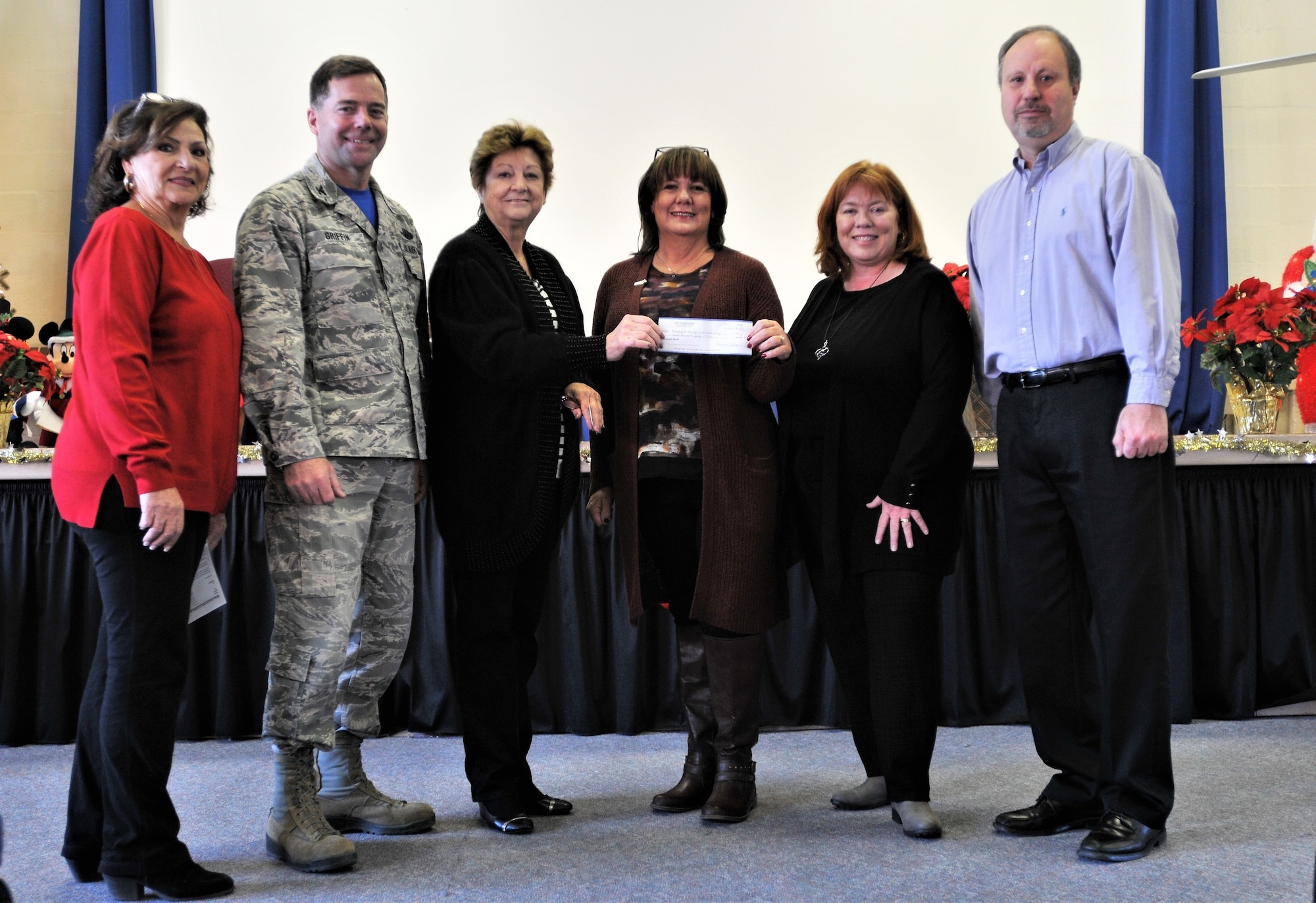 Debbie Moritz, National Alliance of Mental Illness - Bucks County chapter executive director, hands a check to retired Chief Master Sgt. Jenny Pappas, Horsham Air Guard Station Friends of the Family Readiness Group president, Dec. 2, 2017 at Horsham AGS, Pa. The gift was reciprocation for the 111th Attack Wing’s participation in the first March for the 22, an event intended to bring awareness to the daily loss of 22 U.S. veterans to suicide. On Oct. 22, 22 men and women carrying 22-pound rucksacks marched 22 kilometers – from Washington Crossing National Cemetery, Newtown, Pa., to the Doylestown courthouse, Doylestown, Pa. The Veterans of Foreign Wars of the United States, Post 175, Doylestown, was also involved in the march and is represented in the photo by Kurt Mueller, far right. Anna Richar, 111th ATKW Airman & Family Readiness Center, stands with 111th ATKW Commander Col. William Griffin, both on left. Joanne Murray, standing next to Mortiz, is representing the March for the 22 committee. (U.S. Air National Guard photo by Tech. Sgt. Andria Allmond)