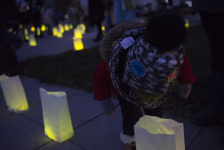 A child looks into a glowing bag during Gunfighter Glow Dec. 8, 2017, at Mountain Home Air Force Base, Idaho. Each glow stick represents an Airman who currently deployed from the 366th Fighter Wing. (U.S. Air Force photo by Senior Airman Lauren-Taylor Levin)