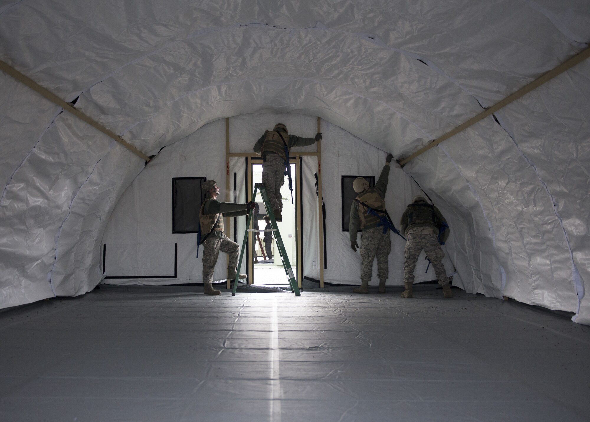 Photo of Airmen from the 366th Civil Engineer Squadron finish the interior of a tent during an exercise Dec. 7, 2017, at Mountain Home Air Force Base, Idaho. The base participated in a week-long training exercise to train for potential real world contingencies. (U.S. Air Force photo by Senior Airman Chester Mientkiewicz)