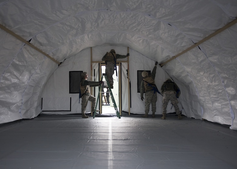 Photo of Airmen from the 366th Civil Engineer Squadron finish the interior of a tent during an exercise Dec. 7, 2017, at Mountain Home Air Force Base, Idaho. The base participated in a week-long training exercise to train for potential real world contingencies. (U.S. Air Force photo by Senior Airman Chester Mientkiewicz)