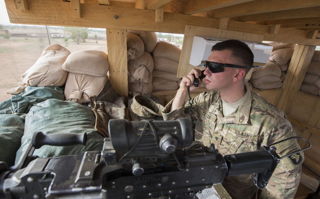 A soldier speaks into a radio microphone