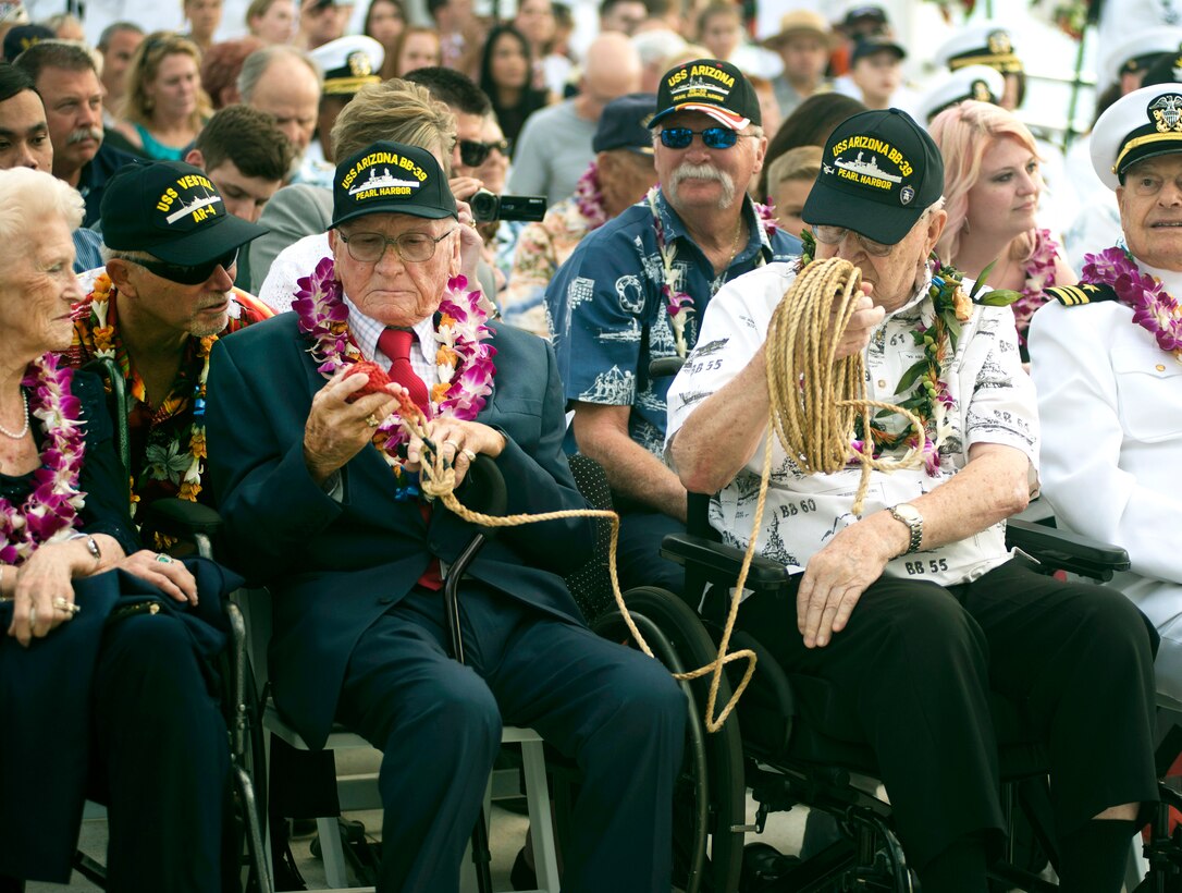 Two veterans sit and look at a rope.