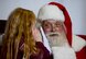 Santa listens as a girl whispers her holiday wishes to him at Dobbins Air Reserve Base, Ga. Dec. 3, 2017. Over the course of the busy December drill weekend, the Clauses set up shop in a hangar to hear the holiday wishes of military members and their families. (U.S. Air Force photo by Don Peek)